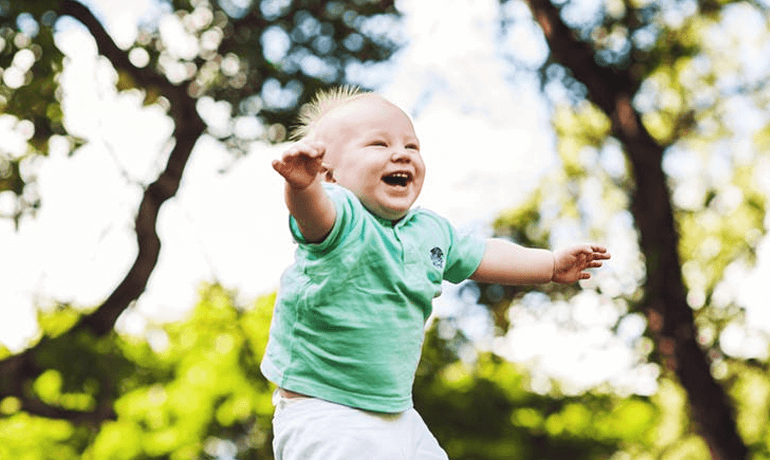 Kid wearing a green shirt laughing